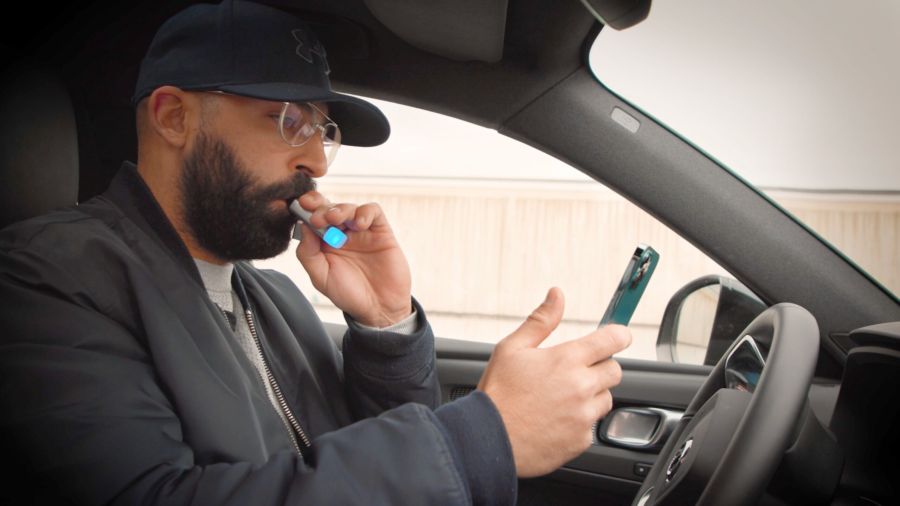A man in a car with a cell phone.