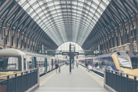 A train station with people walking on the platform.